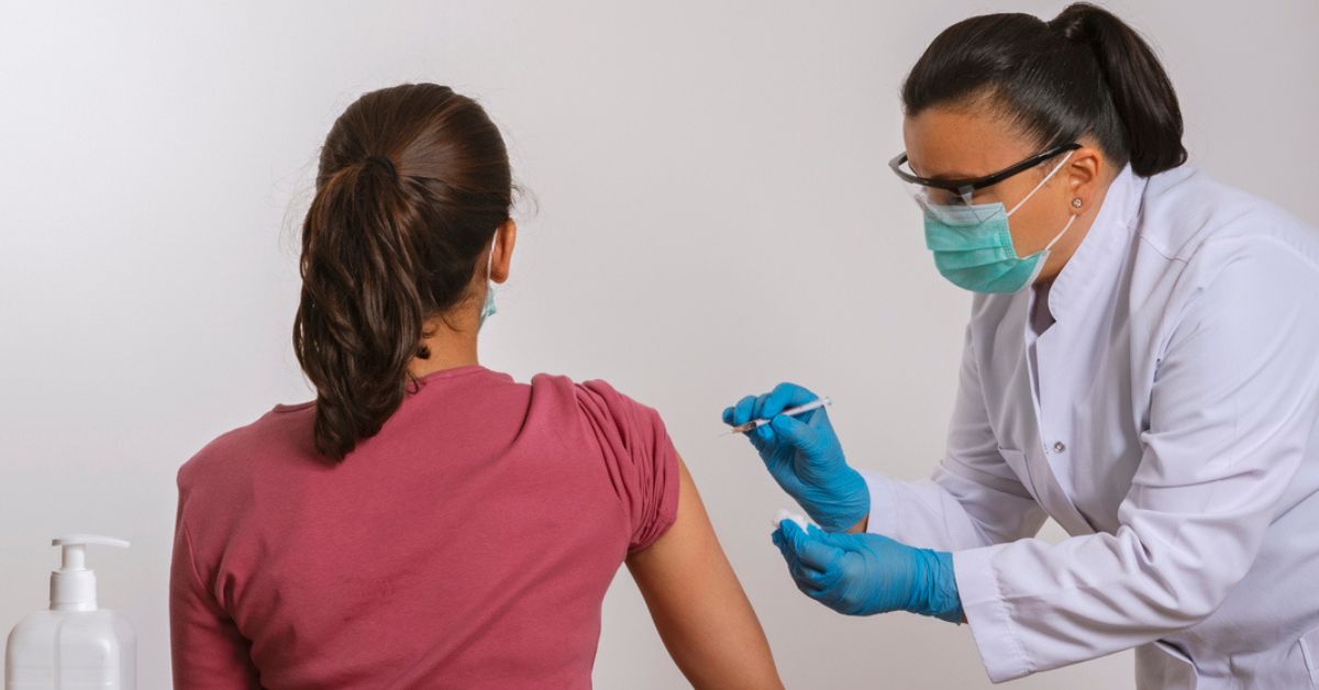 Woman receiving a shot from a doctor in the doctor's office