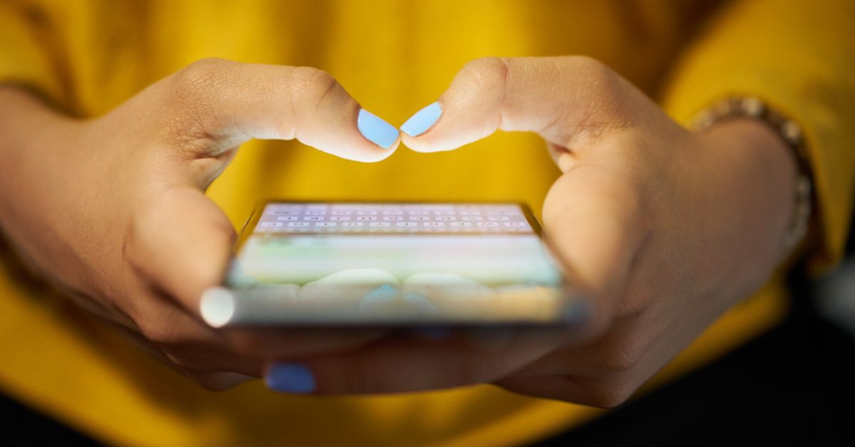 Hands of a woman using social media on her cellphone