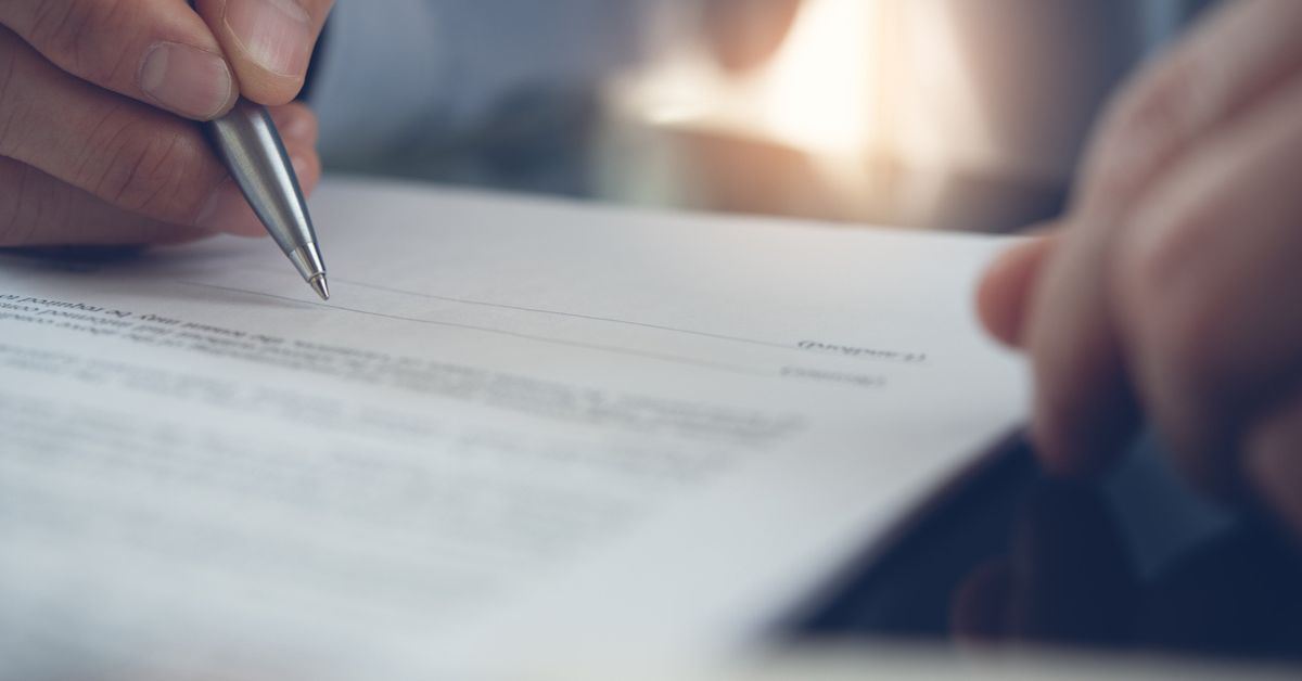 Person about to sign paperwork from an insurance company after receiving an accident settlement.