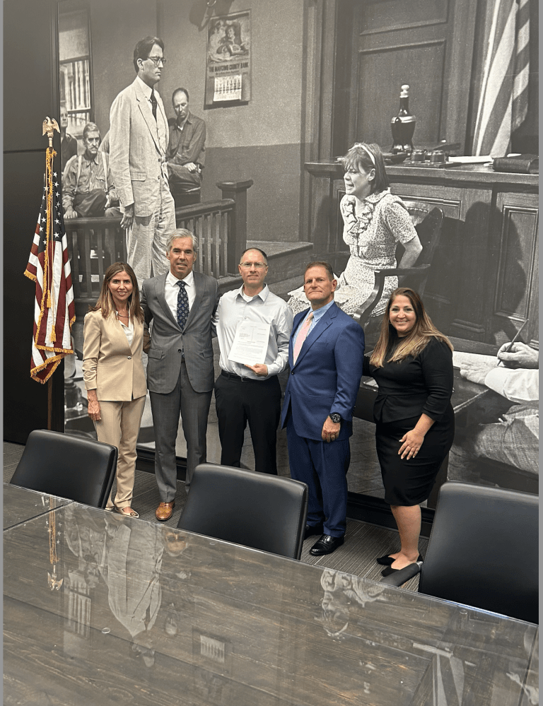 Five people sand in front of a mural depicting a scene from movie "To Kill A Mockingbird"
