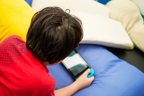 kid play portable online gamming console device by handheld with entertainment in room indoors toy in electronic child user concept