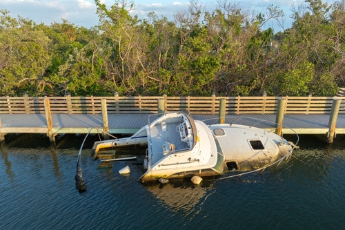 Aerial view of sunken sailboat on shallow bay waters after hurricane in Manasota, Florida