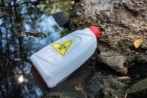A plastic canister with a yellow chemical hazard sign.Environmental pollution by household production waste.The ingress of toxic waste into the soil.