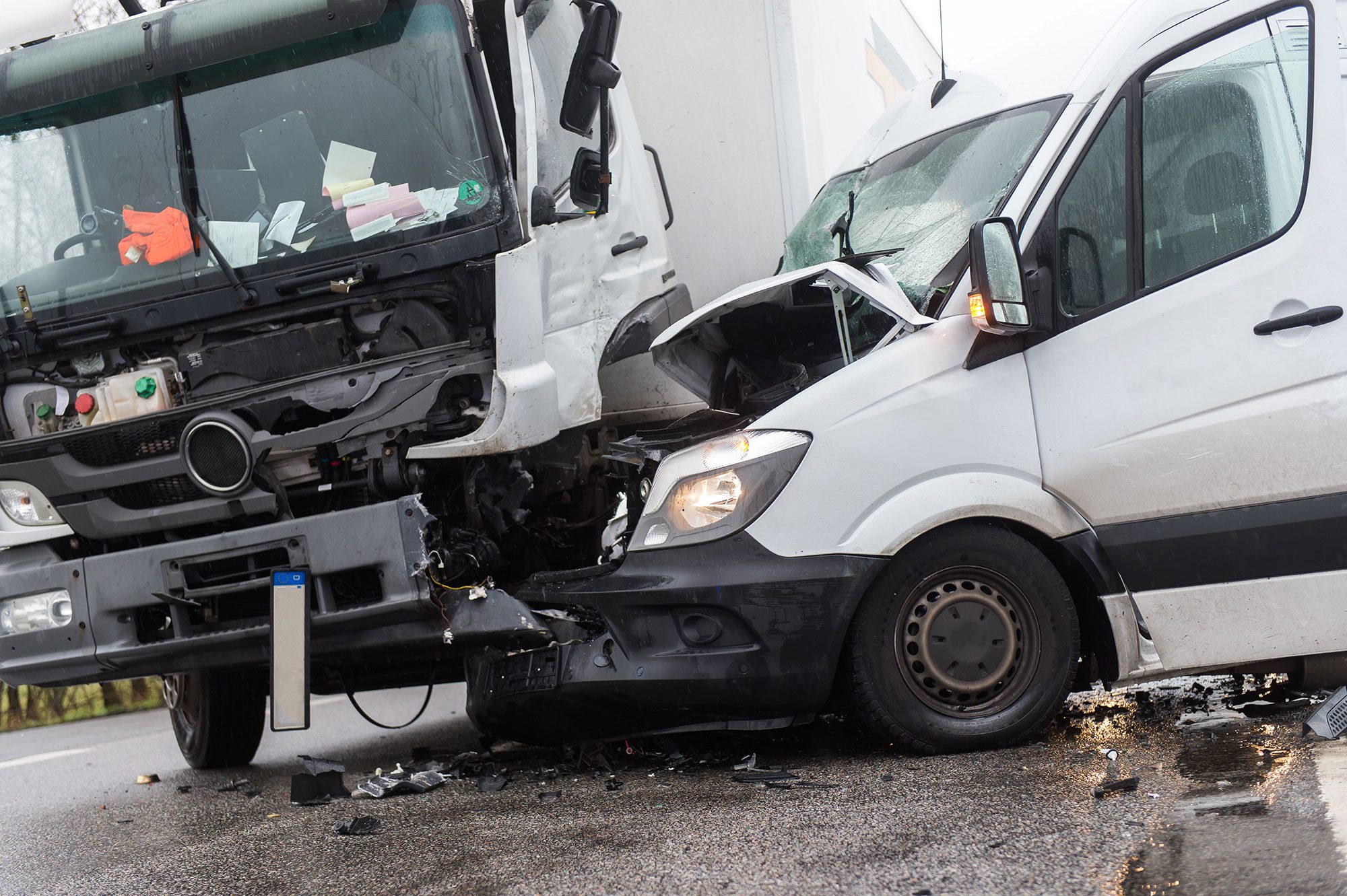 A truck accident where A white van crashed into a big white truck